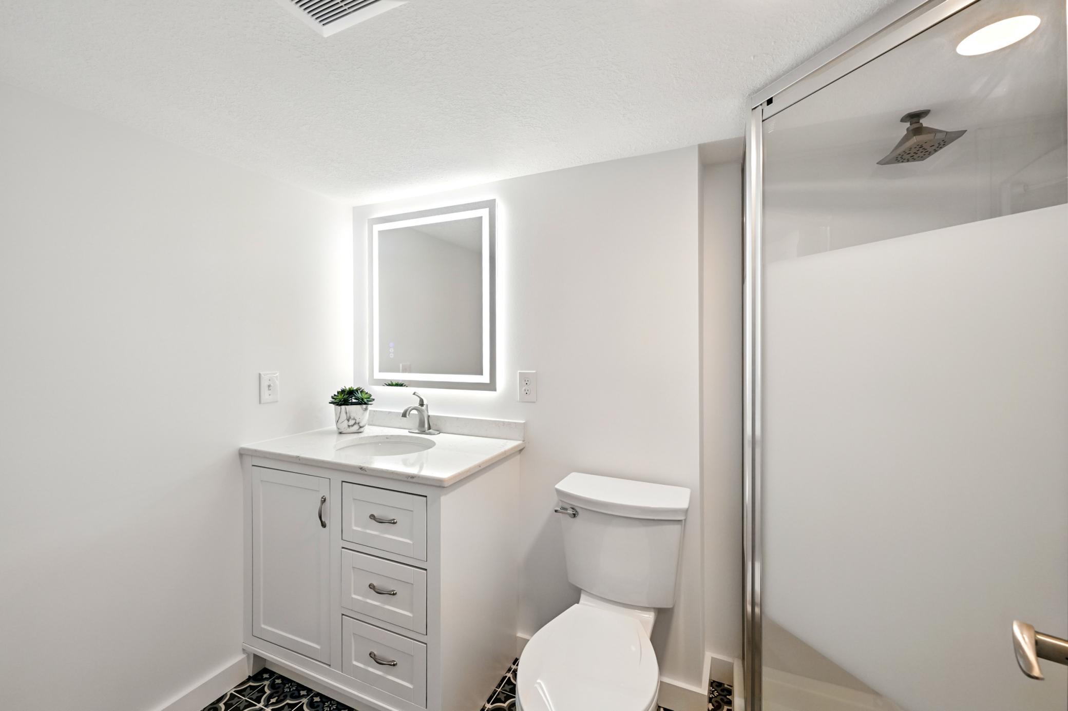 Lower level 3/4 bathroom with a walk-in shower and tile floors