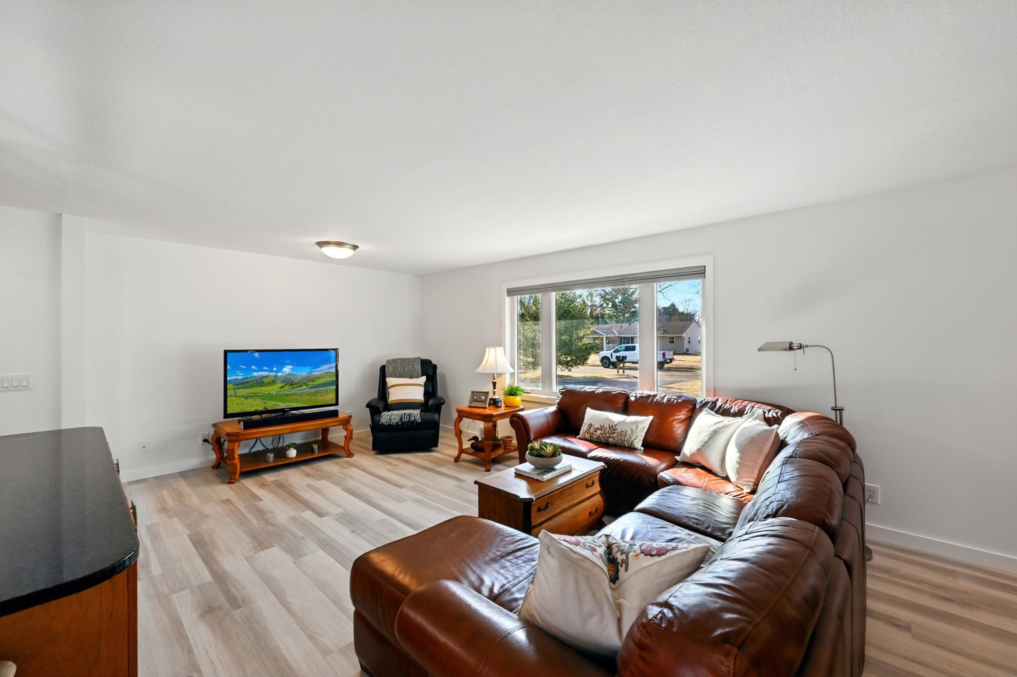 Spacious main level living room with a large window filling the room with natural light