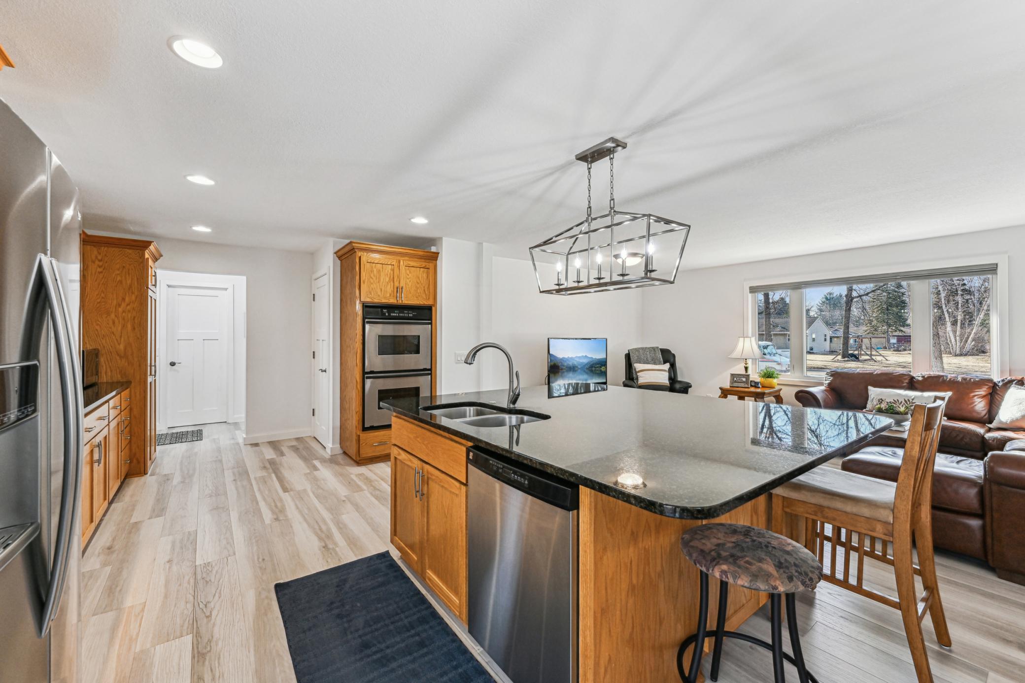 Main level kitchen with stainless steel appliances and new flooring throughout