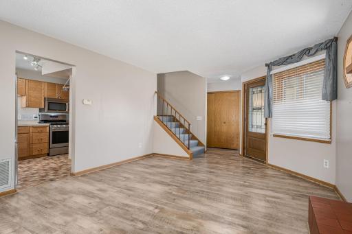 The living area has the smooth layout—easy access to the kitchen, entry, and upper level.