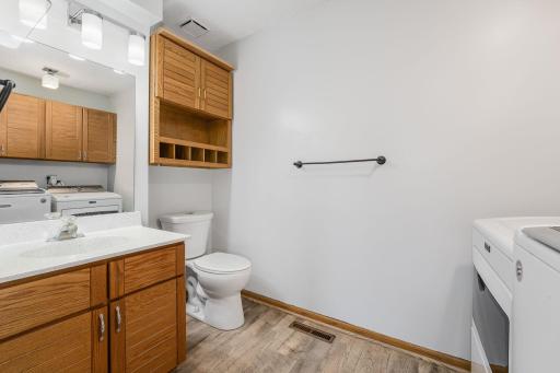 Convenient main floor half bath combined with laundry—complete with storage cabinets and updated lighting.