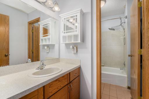 Upper-level full bath with large vanity, updated lighting, and shower/tub combo.