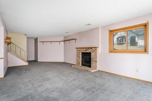 Enjoy the warmth and character of a brick fireplace in this expansive lower-level family room, perfect for entertaining.