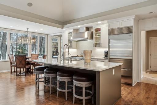 Remodeled kitchen with large center island with seating, stainless steel appliances, custom cabinetry and ample counter space.