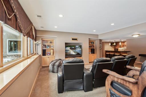 Family room with built in shelving, game area, and bar.