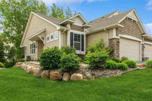 Immaculate curb appeal with well-maintained shrubs, stone accents, and architectural detail above the garage and front window.