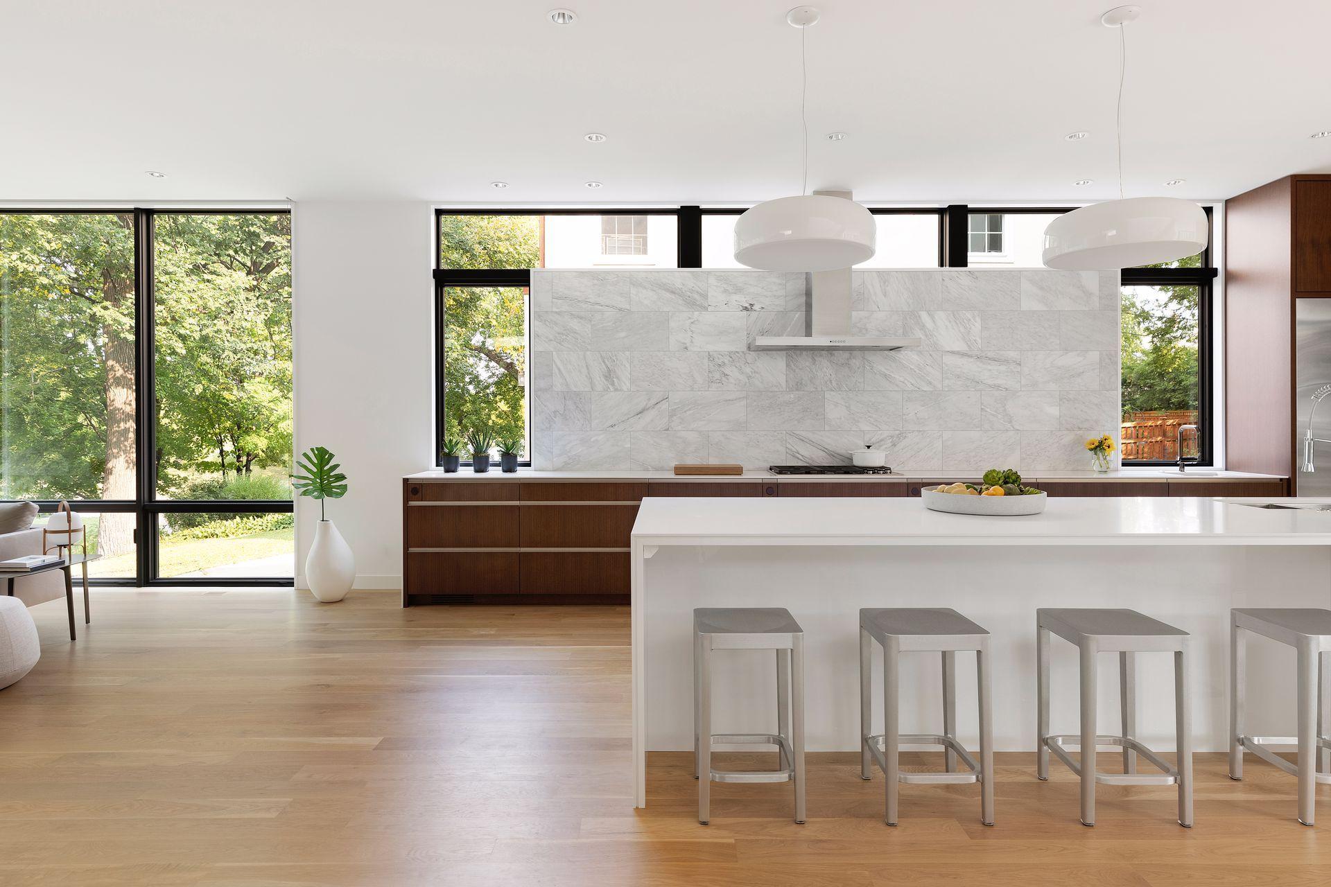 A sleek, modern kitchen with marble, warm wood, and natural light in perfect harmony.