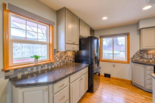 Kitchen with Expanded Counter Space - Additional counter space and upper cabinetry provide practical prep and storage. Multiple windows bring natural light and backyard views. Updated finishes and durable flooring anchor this main-level kitchen.