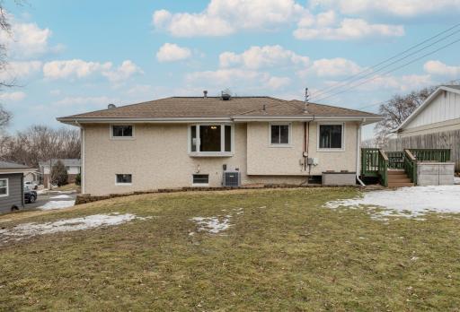 Rear Exterior & Yard - Rear exterior showcases stucco siding, multiple windows, and views of the spacious backyard. The composite deck provides elevated outdoor living, while the gently sloped 9,148 sq ft lot offers usable green space.