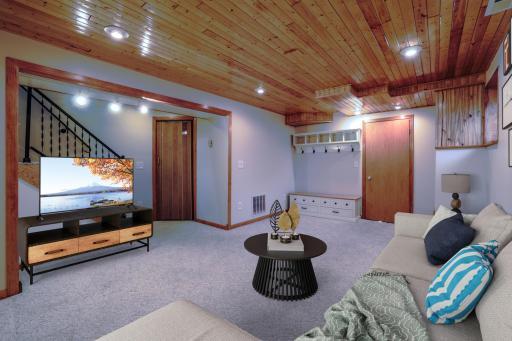 Family Room with Wood Ceiling - Lower-level family room features a tongue-and-groove wood ceiling with recessed lighting, neutral carpet, and flexible space for media, office, or recreation use. (Virtually Staged)