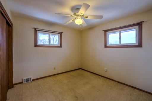 Main-Level Bedroom â Corner Window View â Main-floor bedroom features dual windows for natural light, neutral walls, and hardwood trim. Ceiling fan with light adds comfort. Functional layout offers flexibility for bedroom, office, or guest space.