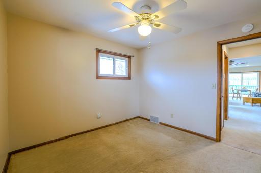 Main-Level Bedroom â View Toward Hall â Bedroom includes ceiling fan, neutral finishes, and closet access. Located off the main hallway near living areas, this room provides practical main-level living with flexible use potential.