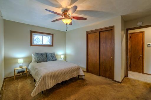 Primary Bedroom â Closet & Hall View â Primary bedroom includes sliding-door closet, ceiling fan, and hardwood trim. Convenient access to main hallway and bath supports practical single-level living.