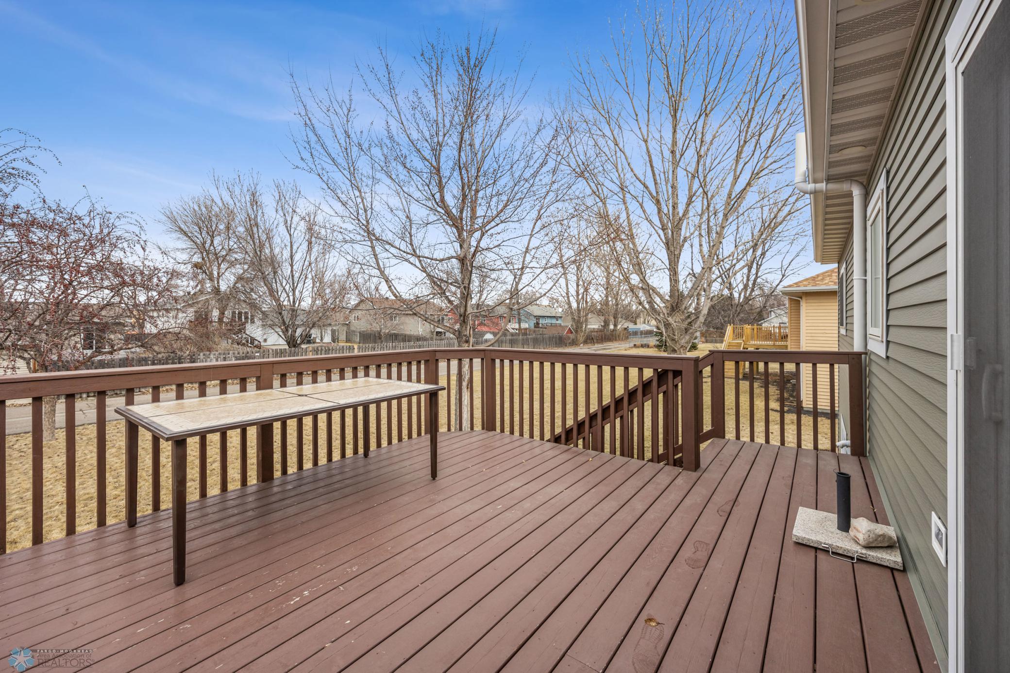Deck overlooks the back yard with mature trees
