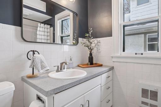 Main level full bathroom with a large vanity providing ample storage space