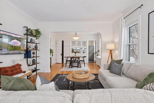 Open concept main level living room and dining room with charming arched doorways