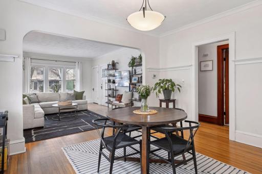 Main level dining room gleaming hardwood floors and arched doorways into the living room
