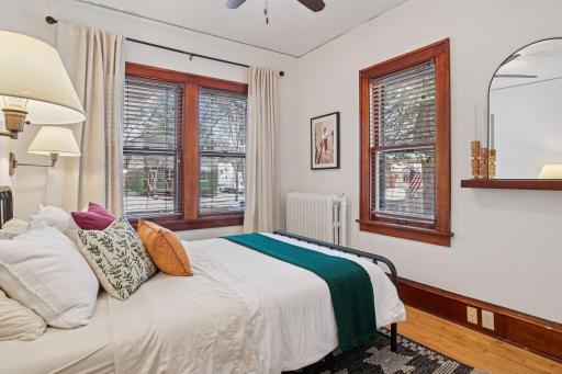 Main level bedroom with gleaming hardwood floors and a large ceiling fan