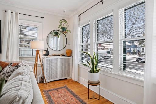 Main level living room with gleaming hardwood floors and views of the front yard