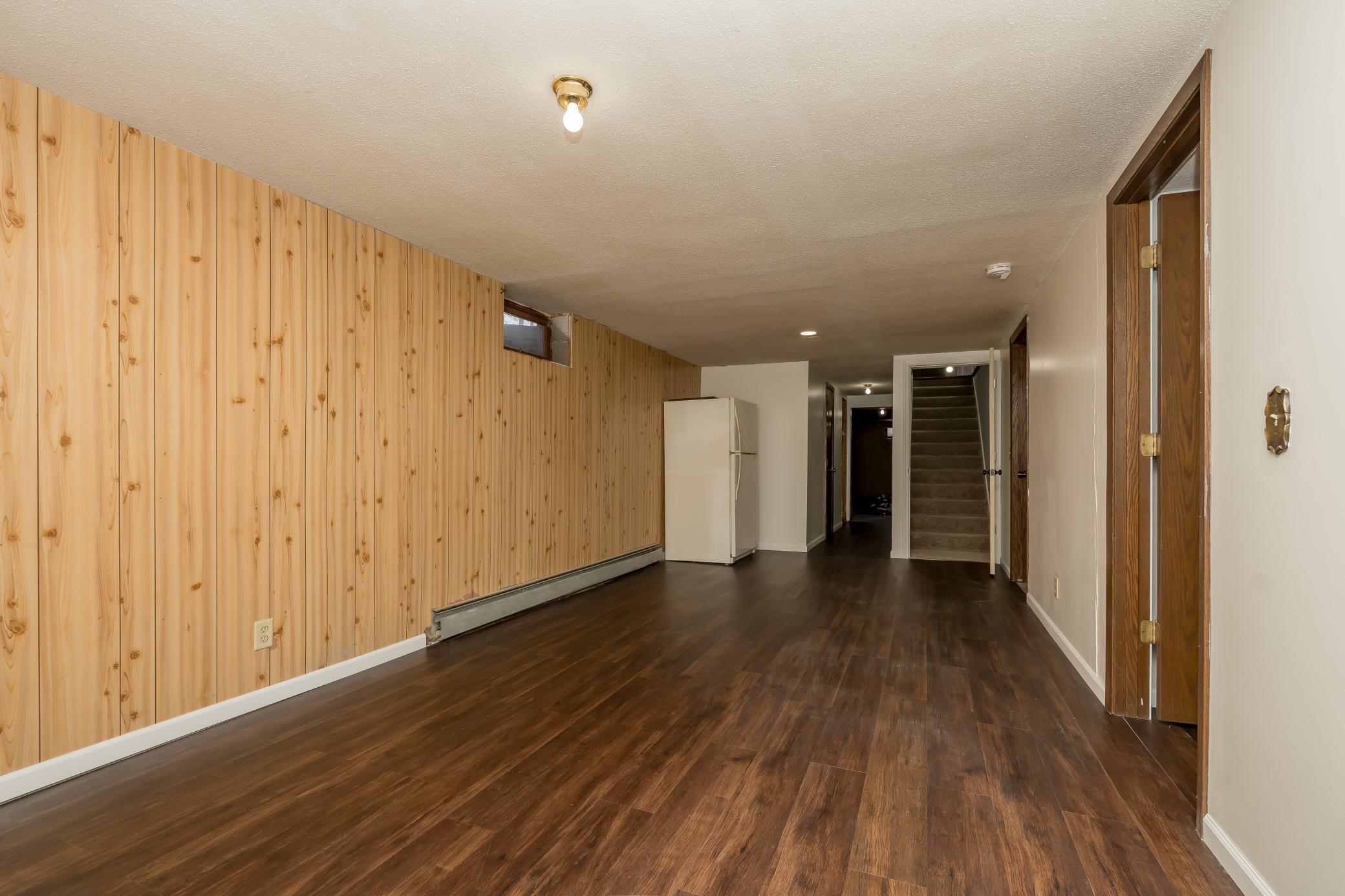 View of the lower level additional living space. Doors lead to additional bedroom and storage rooms
