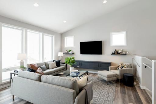 Photos are from previous, similar model. The options, features and color scheme will vary. Actual home will have gas fireplace in lieu of floating shelf. This gathering room brings all the drama with the vaulted ceiling and floor to ceiling windows!
