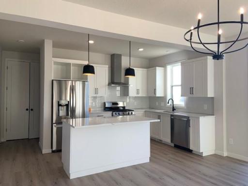 Inspiring kitchen with beautiful quartz countertops, ceramic tile backsplash, stainless steel LG appliances and black accent fixtures! Photos are from previously built home; options and features will vary