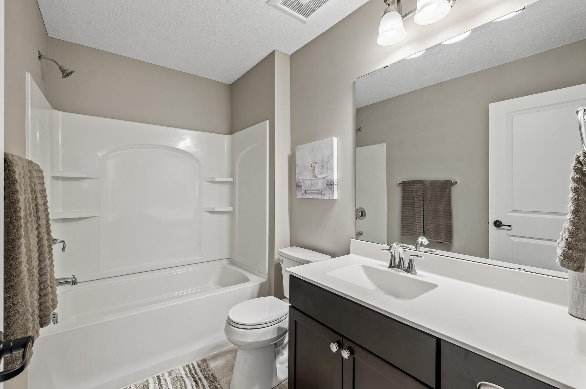 Upper level bathroom is located near each bedroom and offers a spacious vanity with plenty of counter space and large mirror.