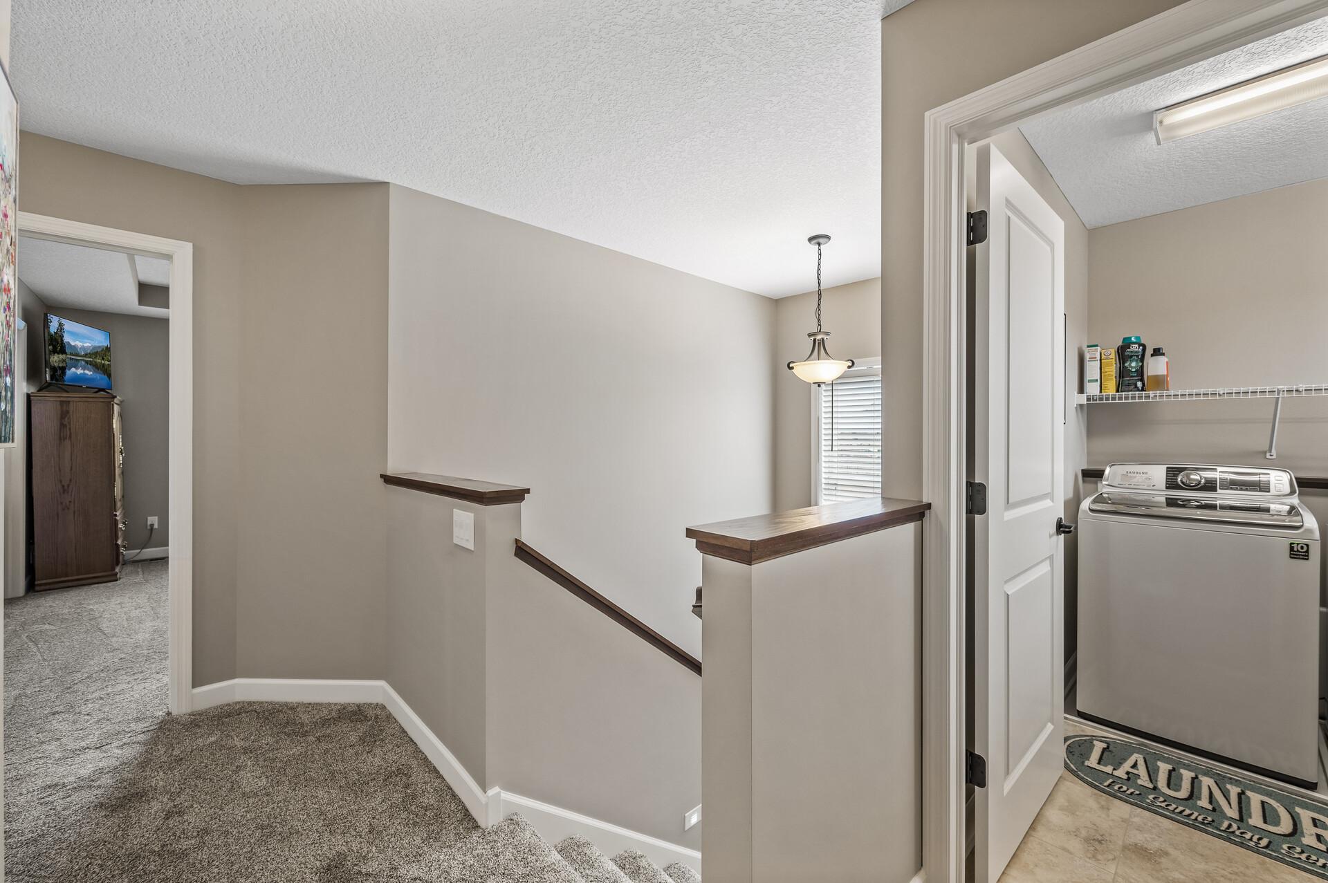 The upper level boasts a laundry room, two additional bathrooms, and four spacious bedrooms, including a luxurious primary suite with a private ensuite.