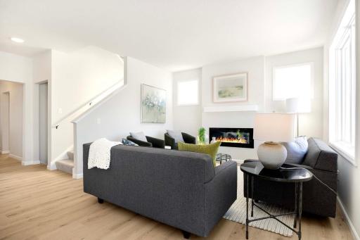 The family room features a sleek and modern electric fireplace that serves as both a functional and stylish centerpiece. Photos are from previously built home; options and features will vary.