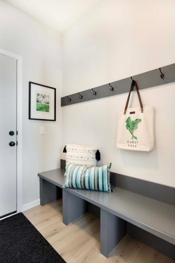 The mudroom features a convenient bench and hooks, perfect for organizing coats, bags, and shoes. Photos are from previously built home; options and features will vary.