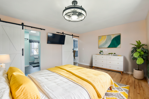 The remodeled primary suite is gorgeous! You will find refinished wood floors, statement barn doors, & a farmhouse light + fan. The private bath has a walk-in tile shower, a fresh vanity + cabinetry, a closet...and even your own washer/dryer!
