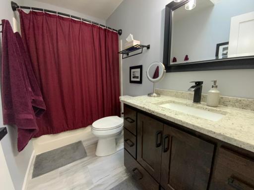 Upper level full bath with walnut custom cabinets.