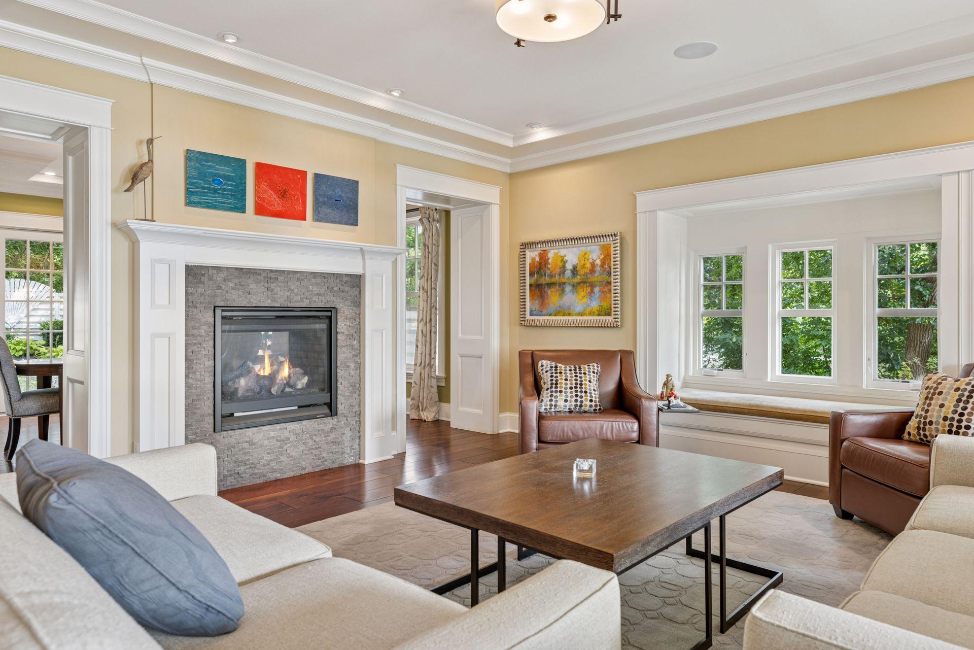 33x16 Fully Renovated Main Level Living room with new south and west facing Marvin Ultimate wood windows, 8-inch solid walnut floors, custom enameled wood work, custom staircase, and double-sided Gas Fireplace.