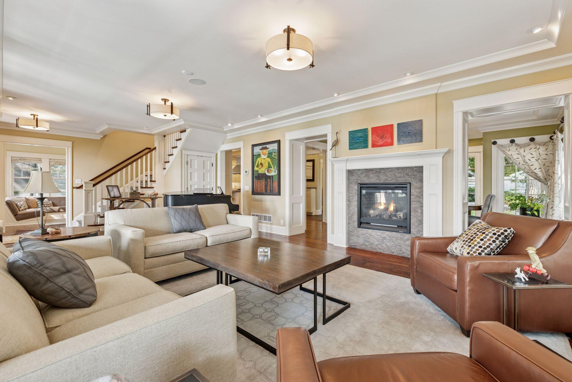 33x16 Fully Renovated Main Level Living room with new south and west facing Marvin Ultimate wood windows, 8-inch solid walnut floors, custom enameled wood work, custom staircase, and double-sided Gas Fireplace.