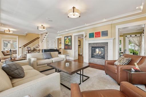 33x16 Fully Renovated Main Level Living room with new south and west facing Marvin Ultimate wood windows, 8-inch solid walnut floors, custom enameled wood work, custom staircase, and double-sided Gas Fireplace.