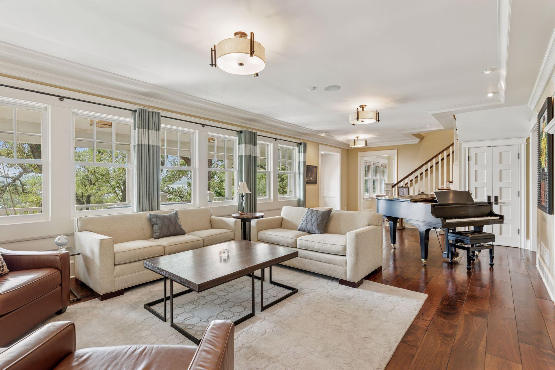 33x16 Fully Renovated Main Level Living room with new south and west facing Marvin Ultimate wood windows, 8-inch solid walnut floors, custom enameled wood work, custom staircase, and double-sided Gas Fireplace.