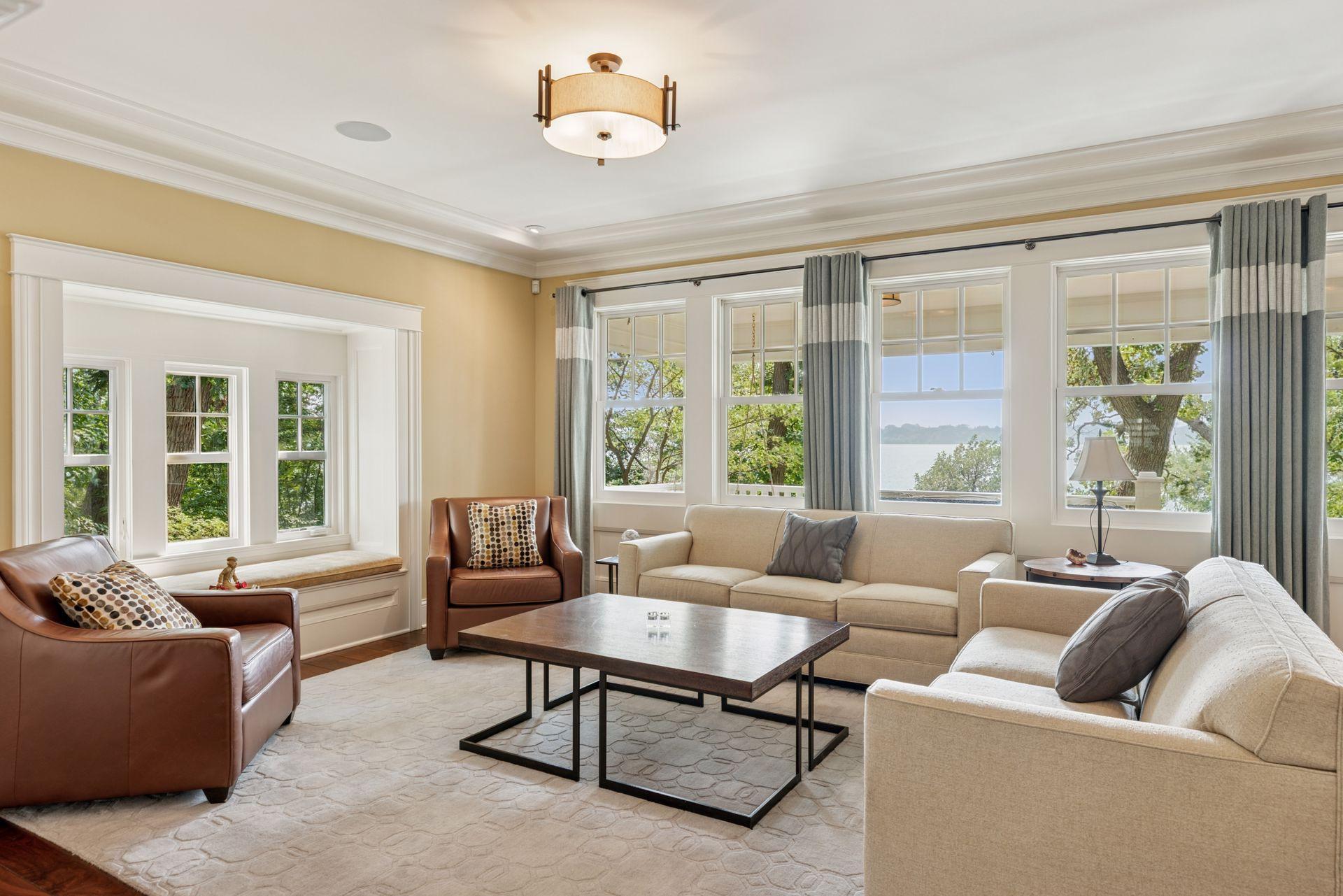 33x16 Fully Renovated Main Level Living room with new south and west facing Marvin Ultimate wood windows, 8-inch solid walnut floors, custom enameled wood work, custom staircase, and double-sided Gas Fireplace.