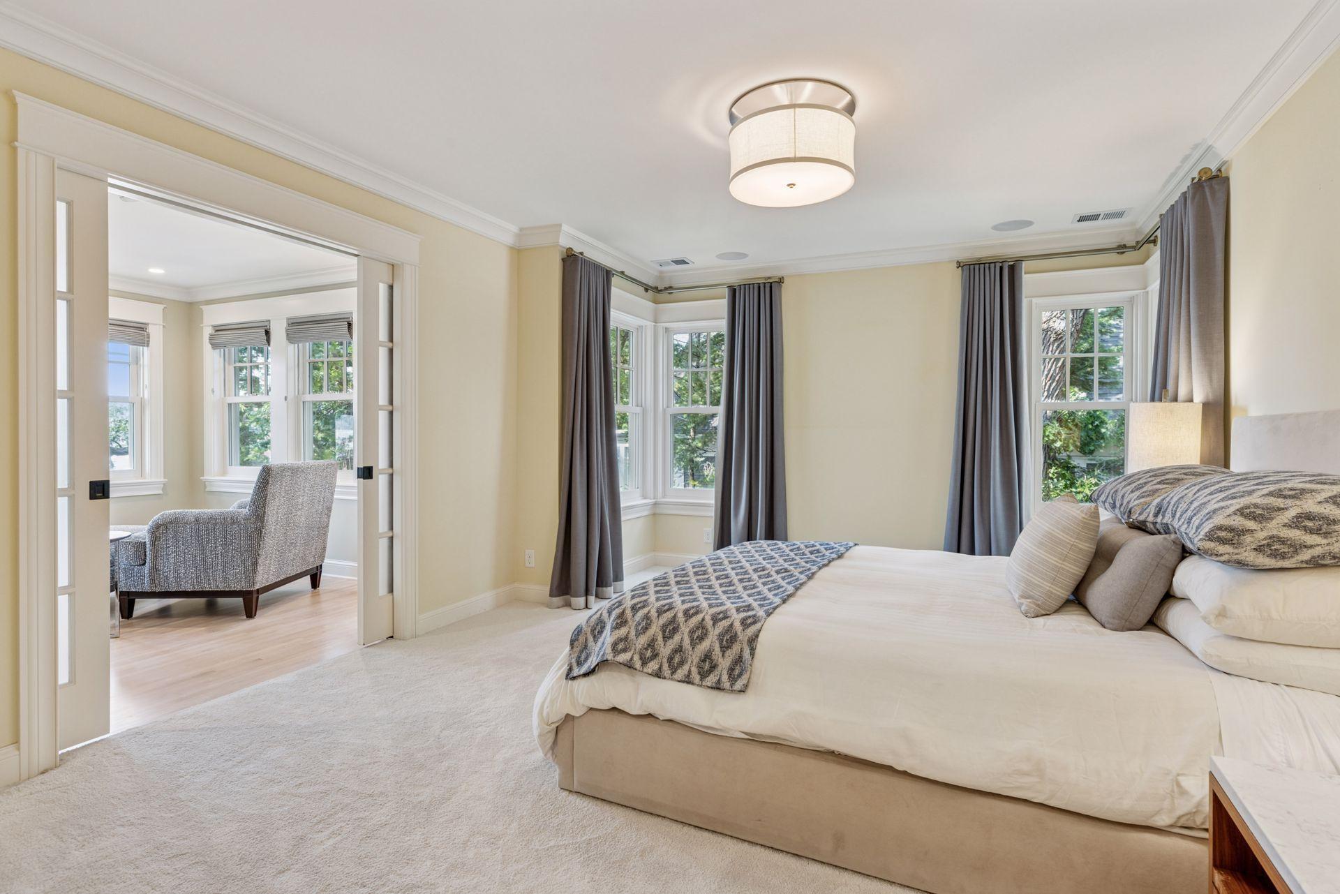 28x13 Fully renovated Primary bedroom with Marvin Ultimate wood windows, custom enameled millworker wool carpeting and frosted pocket doors to the west-facing attached sitting room. West north and east-facing windows.