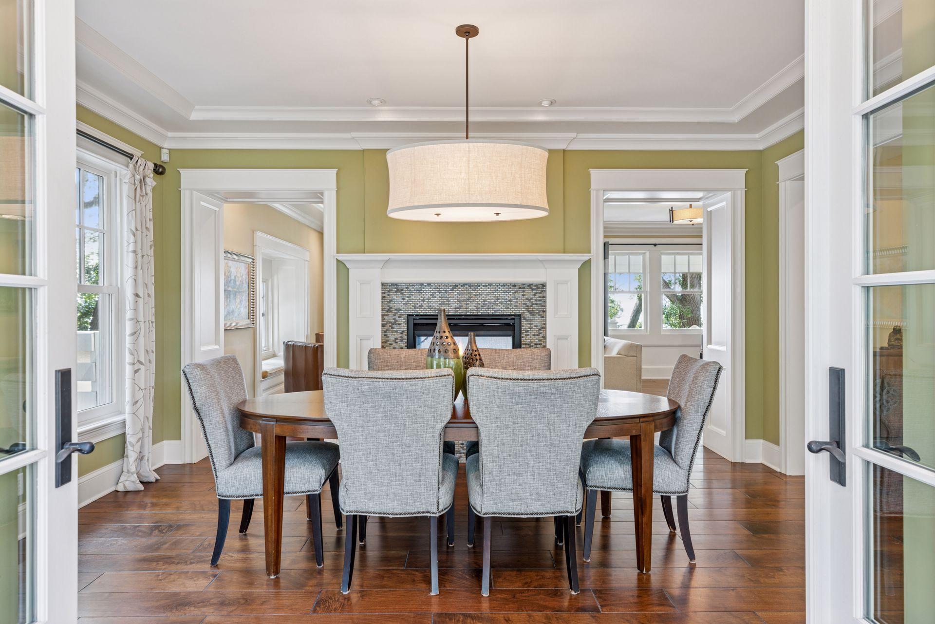 16x15 Fully Renovated Main Level Dining room new east and south-facing Marvin Ultimate wood windows, full glass french doors to the backyard reclaimed paver patio, 8-inch solid walnut floors, custom enameled mill work and double-sided gas fireplace.