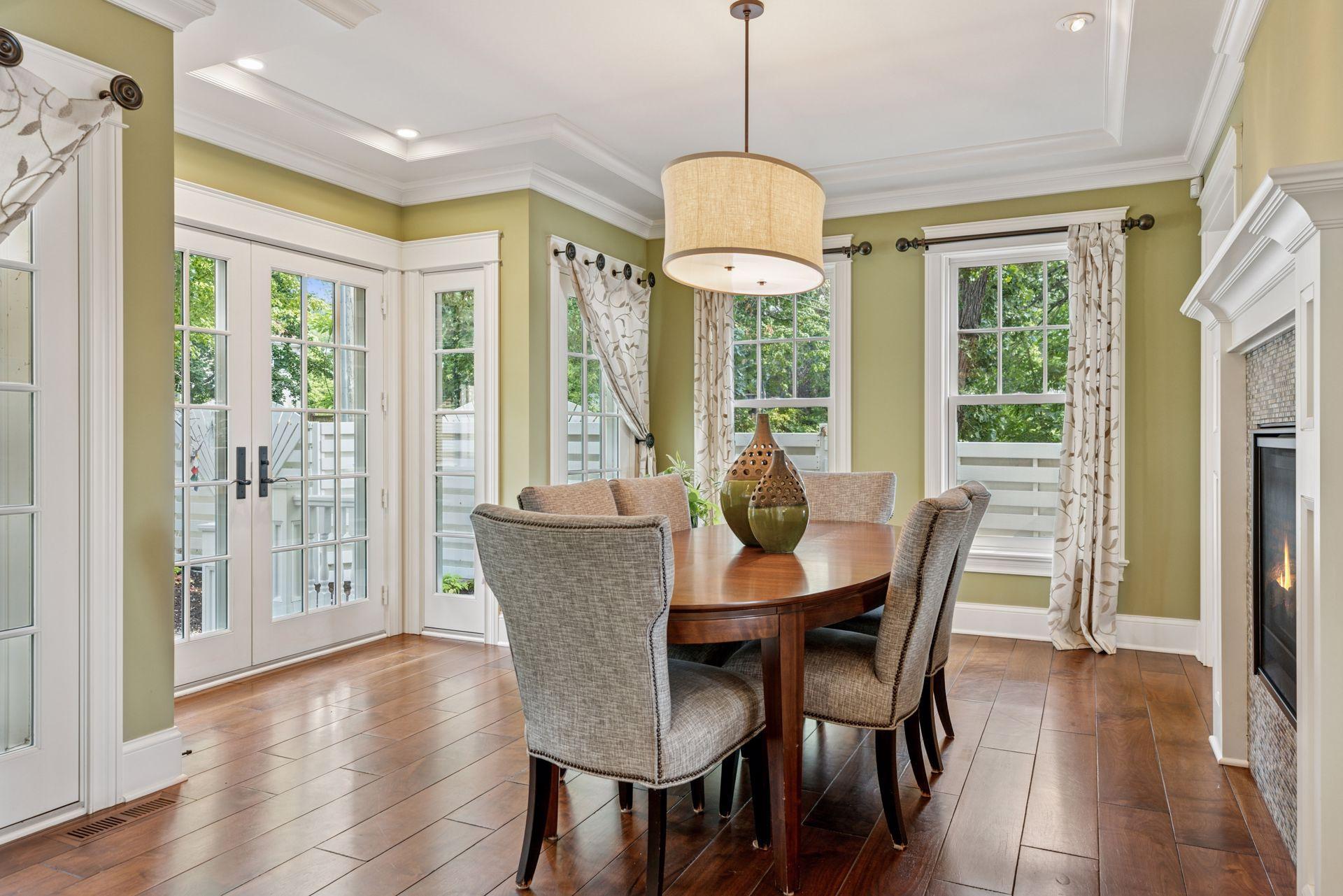 16x15 Fully Renovated Main Level Dining room new east and south-facing Marvin Ultimate wood windows, full glass french doors to the backyard reclaimed paver patio, 8-inch solid walnut floors, custom enameled mill work and double-sided gas fireplace.