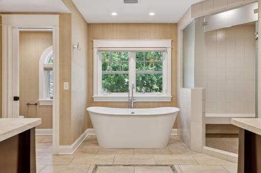 12x11fully renovated Primary bathroom with soaking tub, custom walk in shower, heated towel racks, heated tile floors, double sinks, and attached 12x9 walk in closet. East facing windows.