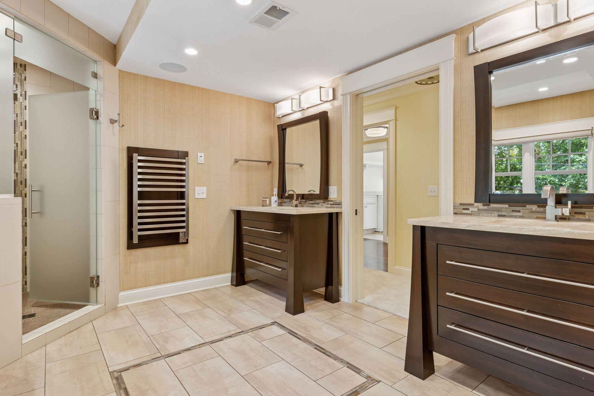 12x11fully renovated Primary bathroom with soaking tub, custom walk in shower, heated towel racks, heated tile floors, double sinks, and attached 12x9 walk in closet. East facing windows.