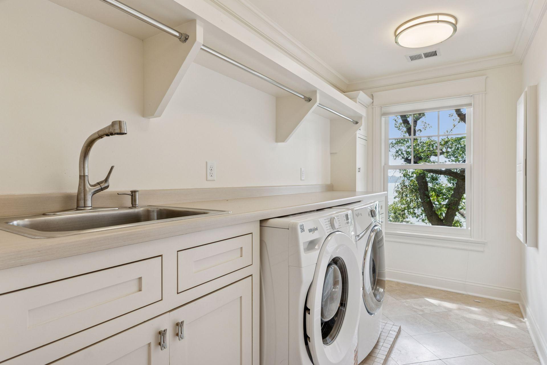 2nd floor fully renovated Laundry room with custom Danners cabinetry, tiled floors, and custom enameled mill work. West-facing windows.