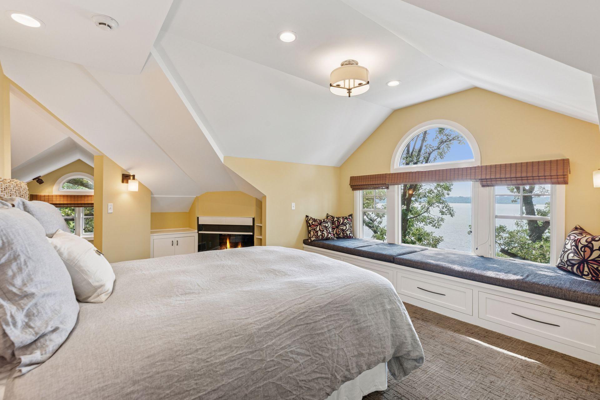 18x15 3rd floor Bedroom #4 with full bathroom suite including soaking tub, fully tiled shower with skylight, enameled millwork, custom built-in cabinetry and seating with west-facing windows of Lake Bde Maka Ska.