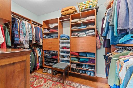 Walk-in-closet with lots of cabinets, shelves and hanging space.
