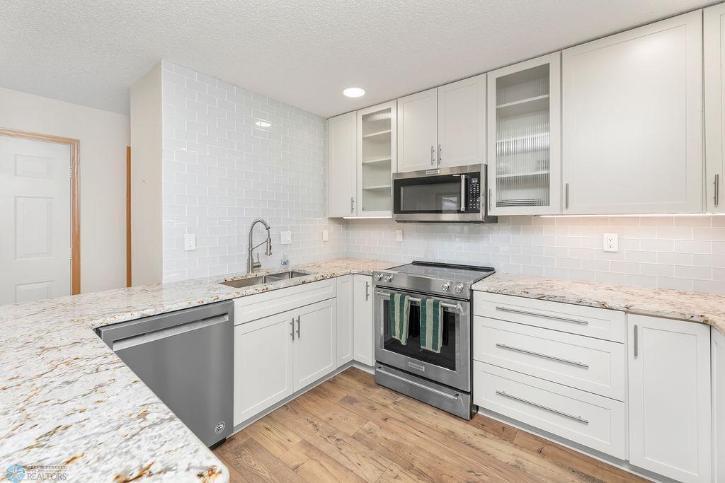 Kitchenaid S/S appliances. Quartz counters. Glass subway tile backsplash.