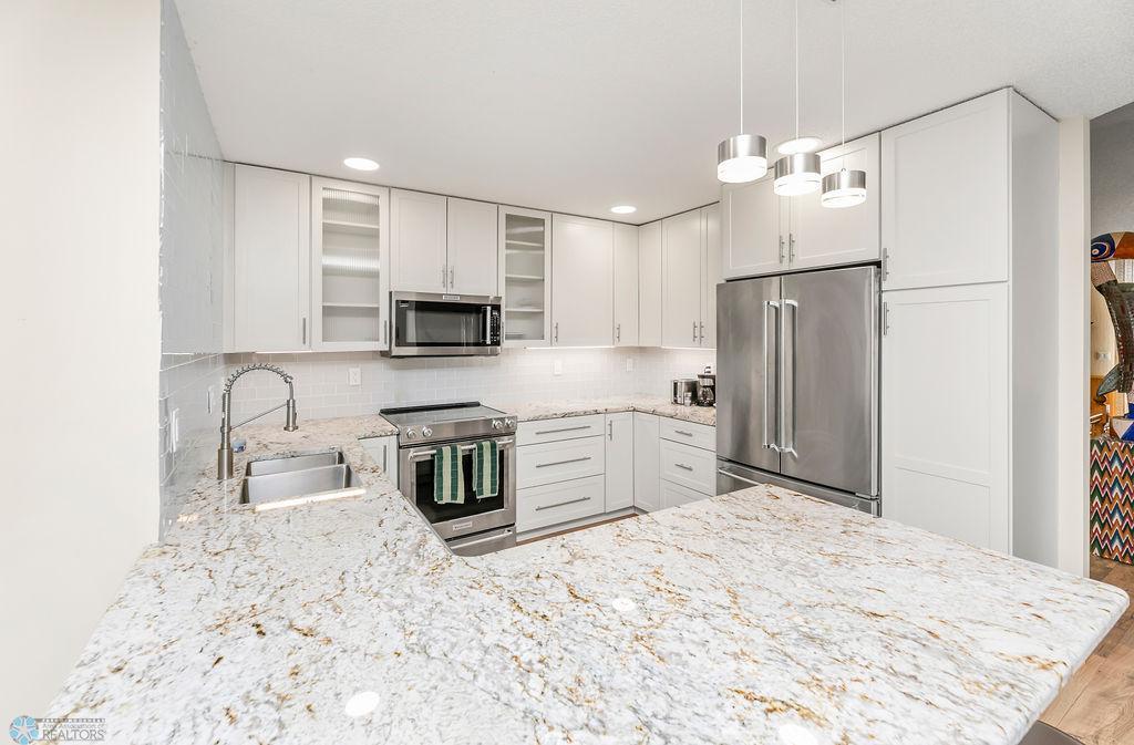 Recessed lighting. Modern pendants. Stainless appliances.