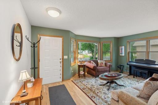 Enter into living room with bay window and plank flooring.