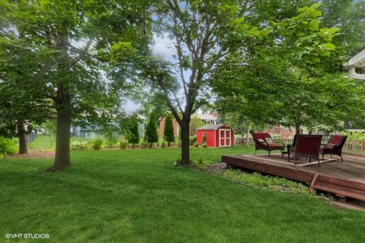Very lush yard with shed & arborvitaes & nice landscaping.