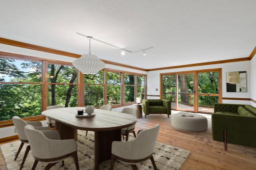 Living Room with a View. Wall-to-wall windows in the living and dining areas flood the space with light and frame the views of the bluff—bringing the beauty of every season right into the heart of the home. virtually staged